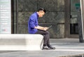 MILAN, ITALY 4 MAY 2019 : Young man using PC for work while sitting on the benchin the square of the city Royalty Free Stock Photo