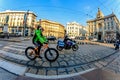 Milan, Italy - October 19th, 2015:Elderly cyclist and a policeman on a motorcycle on the road in the city street Via Cordusio Mila