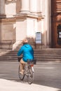 Milan, Italy - September 27, 2020: Elderly woman riding bicycle in the center of Milan. Active old age, people and