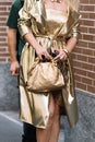 Milan, Italy - September 20, 2023: fashioner wearing Bottega Veneta metallic gold shoulder bag. Fashion blogger outfit