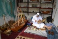 Artisan from Qatar in traditional clothes creating handmade wooden model of ships