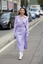 Jessica Wang with lilac skirt and striped shirt walking before MSGM fashion show, Milan Fashion