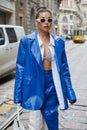 Karina Nigay with electric blue leather jacket and skirt and white leather boots before Ermanno