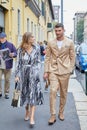 Man with beige suit and woman with black and white dress before Boss fashion show, Milan