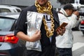Man with big, golden necklace chain and silver bag before Fila fashion show, Milan Fashion Week