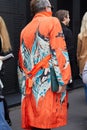 Man with orange trench coat with blue and white design before Gucci fashion show, Milan Fashion