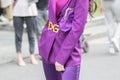 Model wearing a dress, pants and jacket, purple, as well as a purple handbag