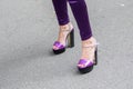 Model wears a pair of purple trousers and a pair of purple high-heeled shoes