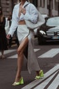 Street style outfit, fashionable woman wearing a pale gray shiny leather split long skirt, a