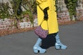 Street style outfit, fashionable woman wears a yellow oversized coat, black and pink print