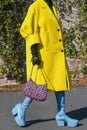 Street style outfit, fashionable woman wears a yellow oversized coat, black and pink print