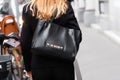 Milan, Italy - September, 21, 2022: stylish women wearing black suit and leather shiny black handbag from Moschino