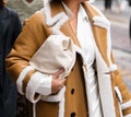 Milan, Italy - September, 21, 2022: Stylish women wearing sheepskin coat and white handbag, street style outfit