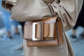 Woman with brown leather bag and beige coat before Bottega Veneta fashion show, Milan Fashion
