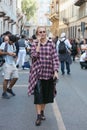 Woman with checkered shirt and black leather skirt before Giorgio Armani fashion show, Milan