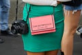 Woman with Emporio Armani pink bag, Canon camera and green skirt before Fendi fashion show,