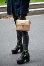 Woman with Gian Marco Venturi golden leather bag and black trousers before Emporio Armani