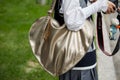 Woman with golden, metallic heart shaped bag before Emporio Armani fashion show, Milan Fashion