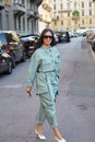 Woman with green blue overalls and sunglasses before Salvatore Ferragamo fashion show, Milan