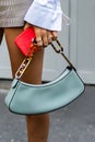 Milan, Italy - September, 21, 2022: woman holding mint green matte leather pouch handbag from Fendi, street style outfit
