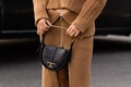 Milan, Italy - September, 23: woman influencer wearing shoulder bag with gold T logo from Tod's or Tods. Fashion