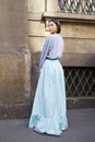Woman with pale blue long skirt and sweater in pink and purple colors before Blumarine fashion