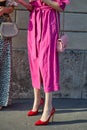 Woman with pink trench coat and red high heel shoes before Tods fashion show, Milan Fashion