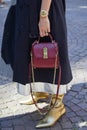 Woman with steel and gold Rolex Daytona watch and red leather Ferragamo bag before Msgm fashion Royalty Free Stock Photo