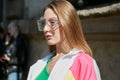 Woman with transparent glasses and white, pink, green sweatsuit before Sportmax fashion show,