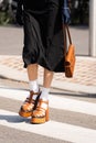 Milan, Italy - September, 22, 2022: woman wearing brown camel leather crocodile pattern handbag, white flower pattern