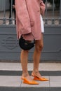 Milan, Italy - September, 21, 2023: woman wears orange brushed leather pumps, high heels from Prada and shoulder bag Royalty Free Stock Photo