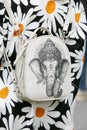 Woman with white backpack with elephant design and jacket with daisies before Emporio Armani