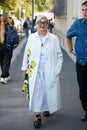 Woman with white coat with yellow roses before Prada fashion show, Milan Fashion Week street