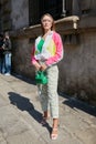 Woman with white, pink, yellow sweatsuit jacket and zebra striped trousers before Sportmax