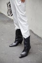 Woman with white trousers and black leather boots before Boss fashion show, Milan Fashion Week