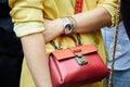 Woman with yellow jacket, red leather jacket and Rolex watch before Fendi fashion show, Milan