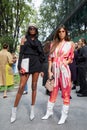 Women with white, pink and orange dress and woman with black dress before Emporio Armani