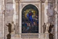 Milan, Italy Virgin Mary glass window art detail, on illuminated gothic style Roman Catholic Duomo Cathedral facade at the homonym Royalty Free Stock Photo