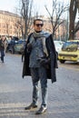 Elegant man with blue decorated suit and gray scarf before Daks fashion show, Milan Fashion Week street style