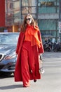 Eleonora Carisi poses for photographers with orange coat and trousers before Emporio Armani fashion show on