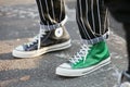 Man with green Converse All Stars glitter sneakers and black and white striped trousers before Diesel Black