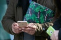 Man with green Furla bag with geckos decoration and iPhone before Emporio Armani fashion show, Milan Fashion