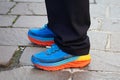 Man with Hoka One Bondi 5 shoes in blue, orange and yellow colors before MSGM fashion show, Milan Fashion Week