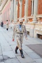 Bryanboy with leopard coat and black boots walking before MSGM fashion show, Milan Fashion Week street style on