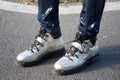 Man poses for photographers with silver crocodile leather Moschino shoes before Giorgio Armani fashion show on