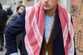 Man with red kaffiyeh scarf and brown velvet jacket before Fendi fashion show, Milan Fashion Week street style