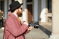 Photographer with red coat and black hat before MSGM fashion show, Milan Fashion Week street style on January