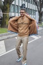 Simone Marchetti with brown sweater with `Nonchalance` writing before Giorgio Armani fashion show, Milan