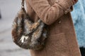 Woman with brown fur Patrizia Pepe bag before Pal Zileri fashion show, Milan Fashion Week street style on Royalty Free Stock Photo