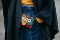 Woman with colorful leather Burberry bag and blue jeans trousers before Giorgio Armani fashion show, Milan